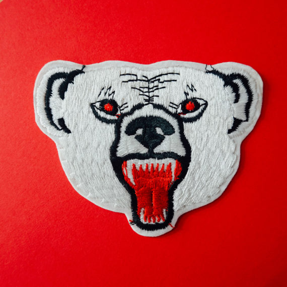 A patch of a polar bear on a red background.