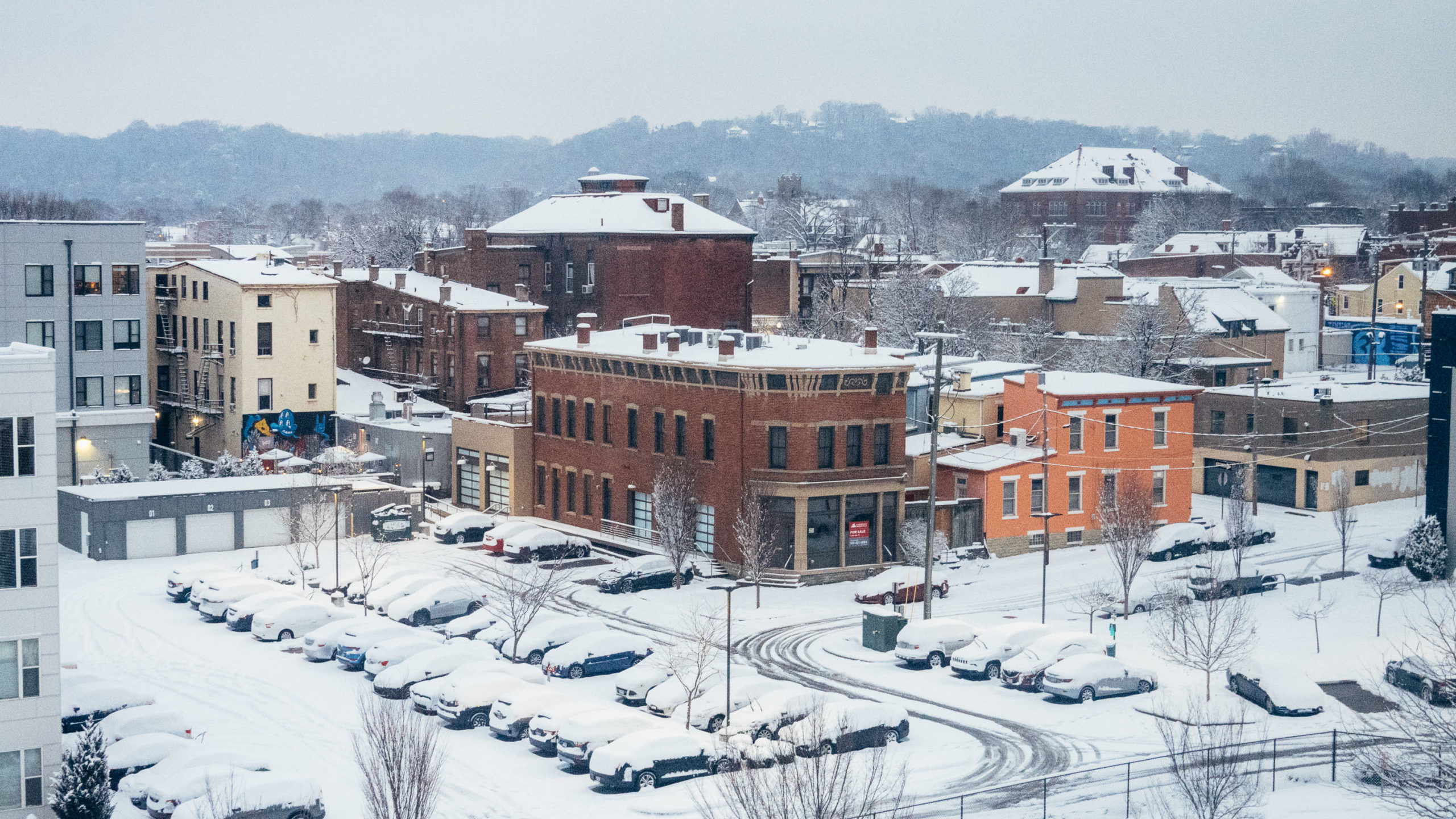 A snow covered neighborhood and parking lot