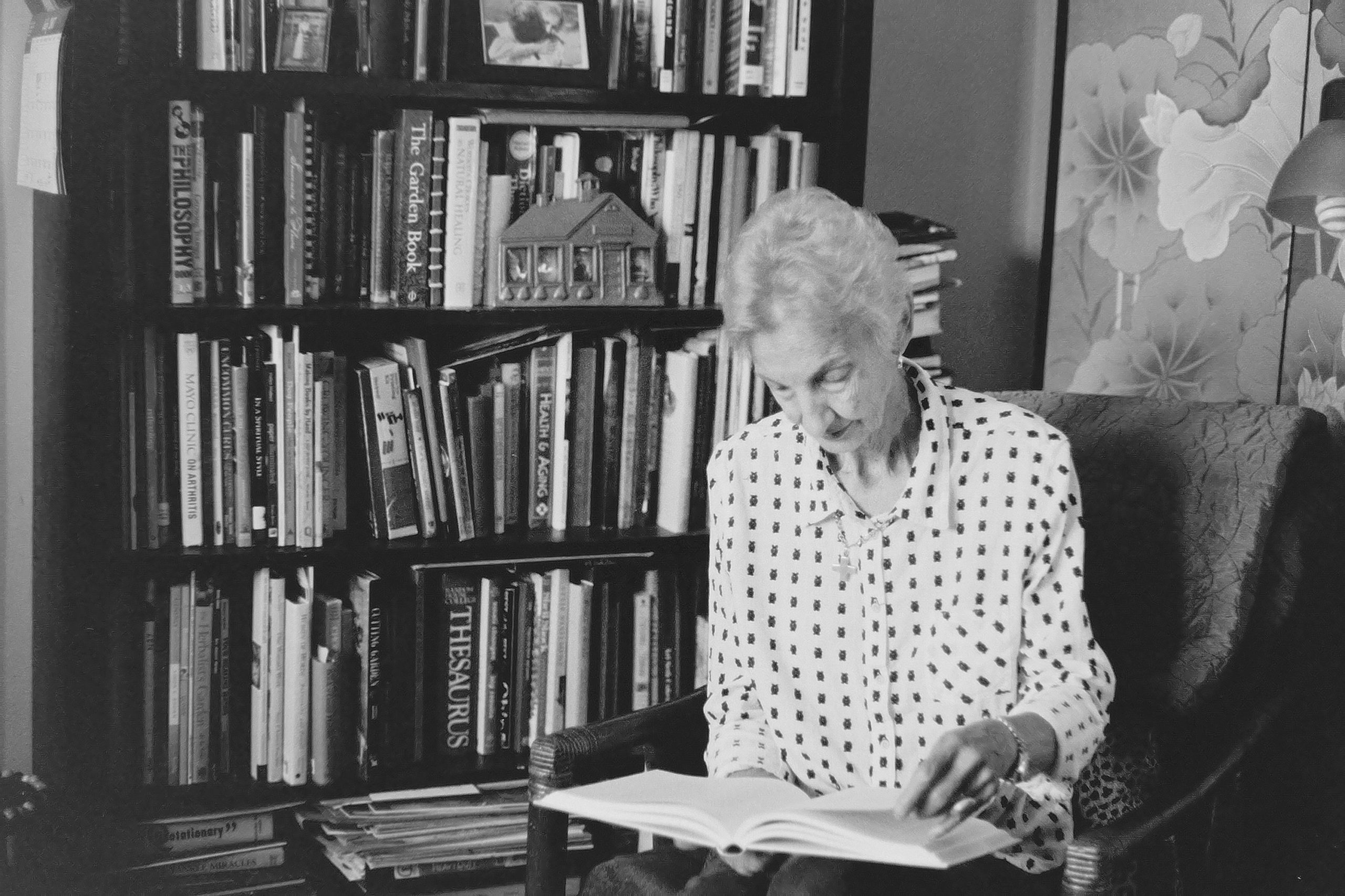 A black and white photo of a woman reading a book