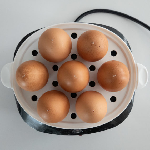 An egg cooker with 7 eggs, photographed from overhead