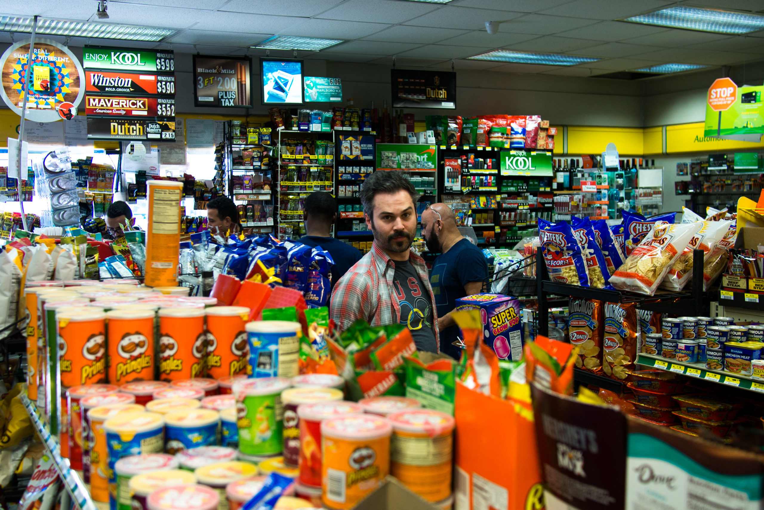 Man standing in aisle of a crowded mini mart