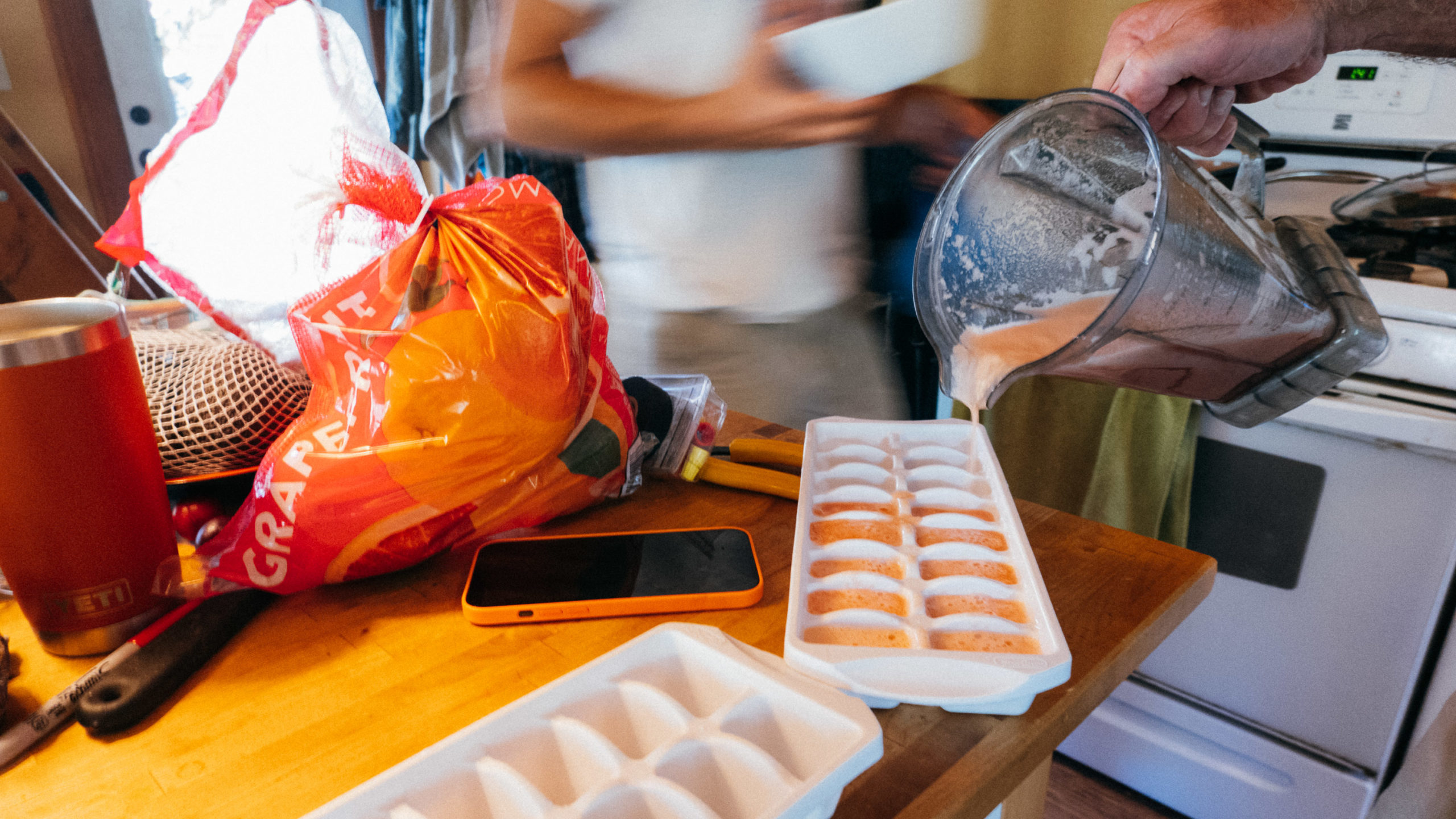 Pouring grapefruit juice into ice cube trays