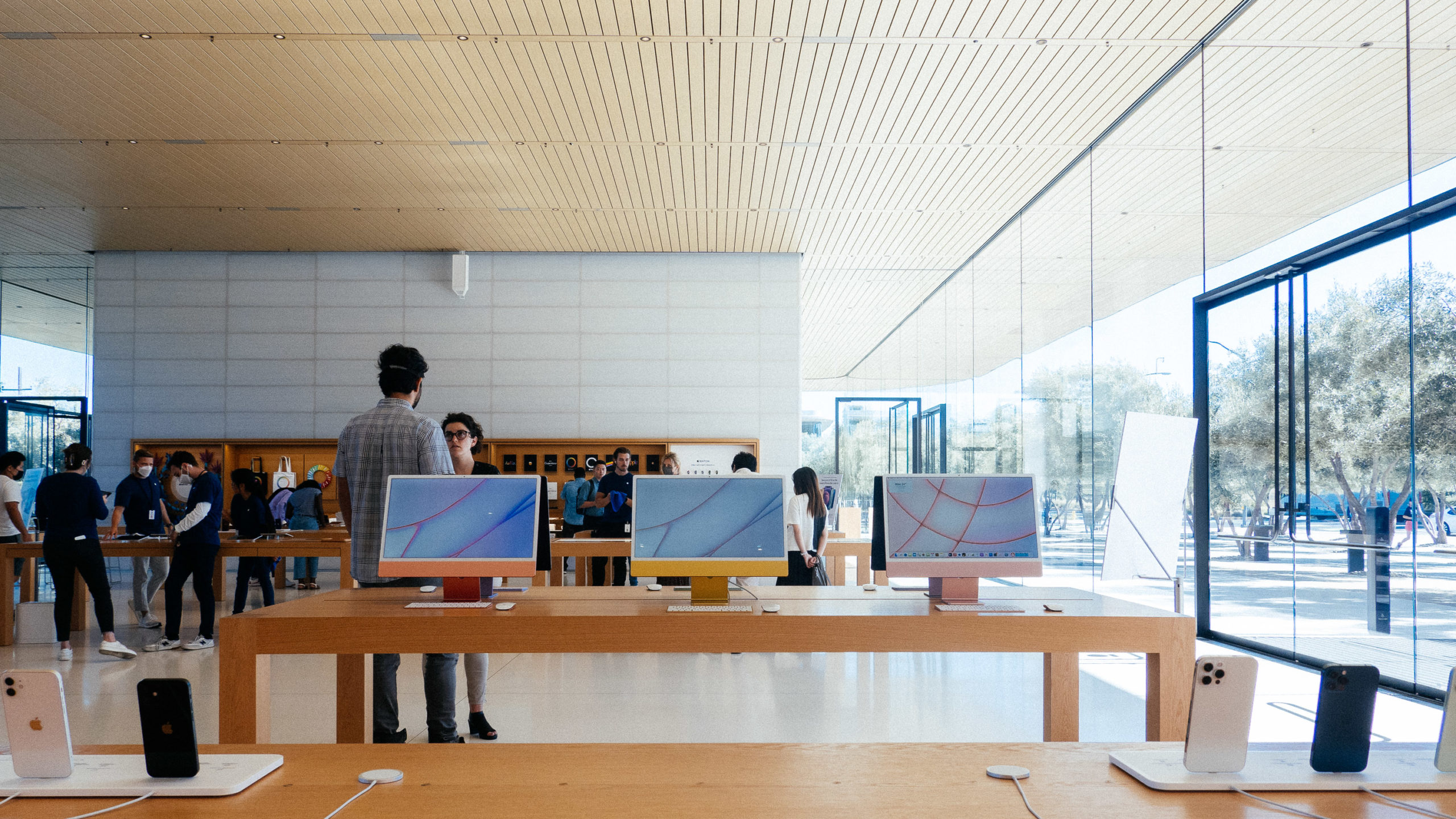 Three iMacs in pastel orange, yellow and red