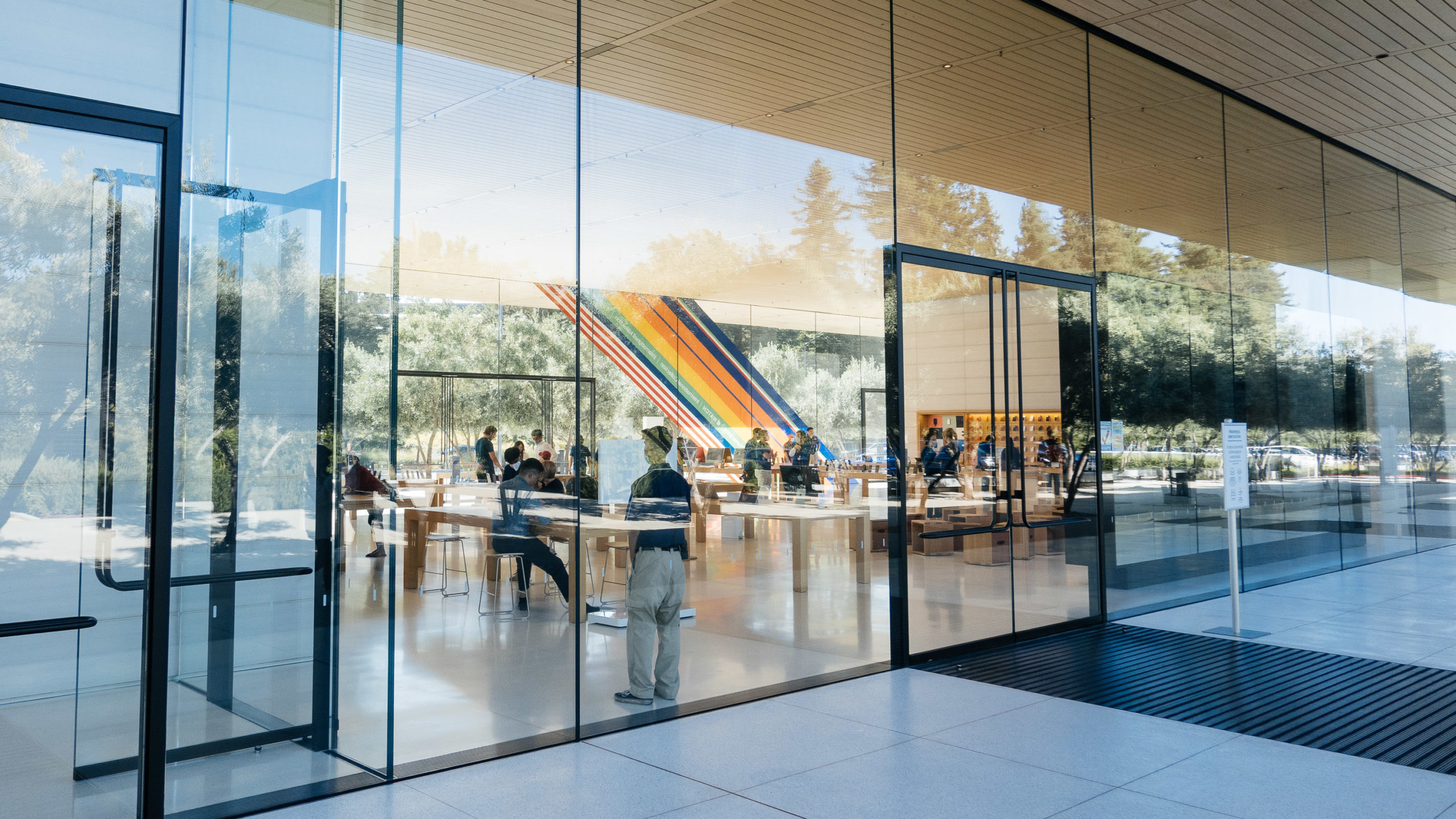 Viewing through large panes of glass, the interior of an Apple Store is revealed