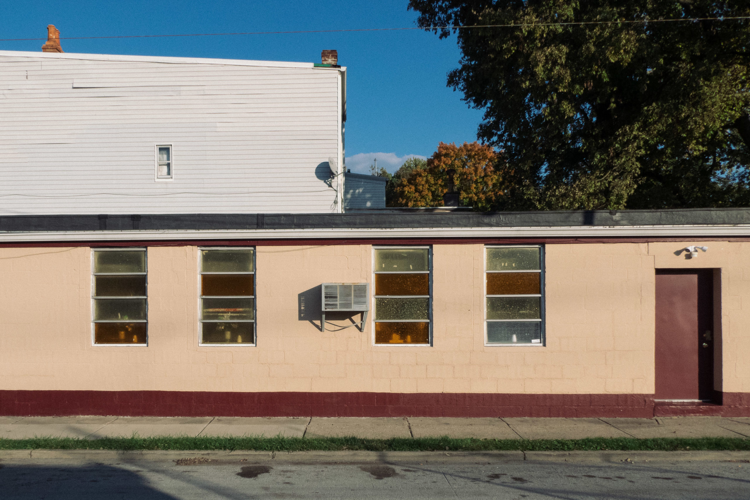 Colored window and an air-conditioning unit on a tan building