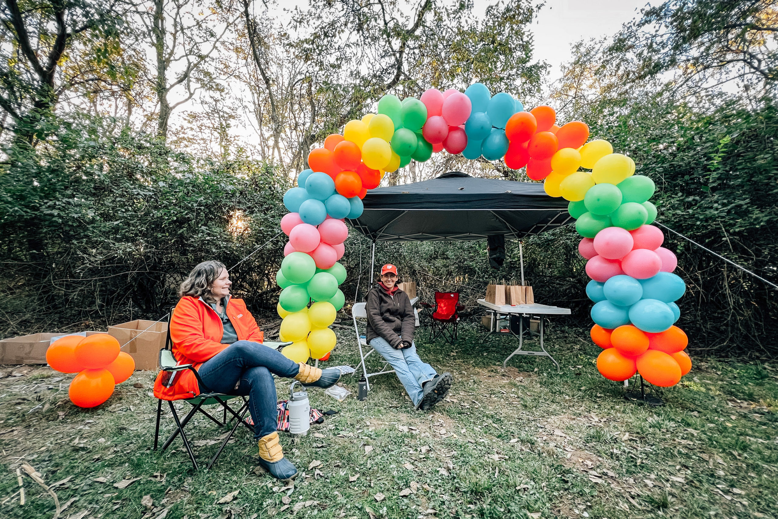 Two women seated under a balloon arch