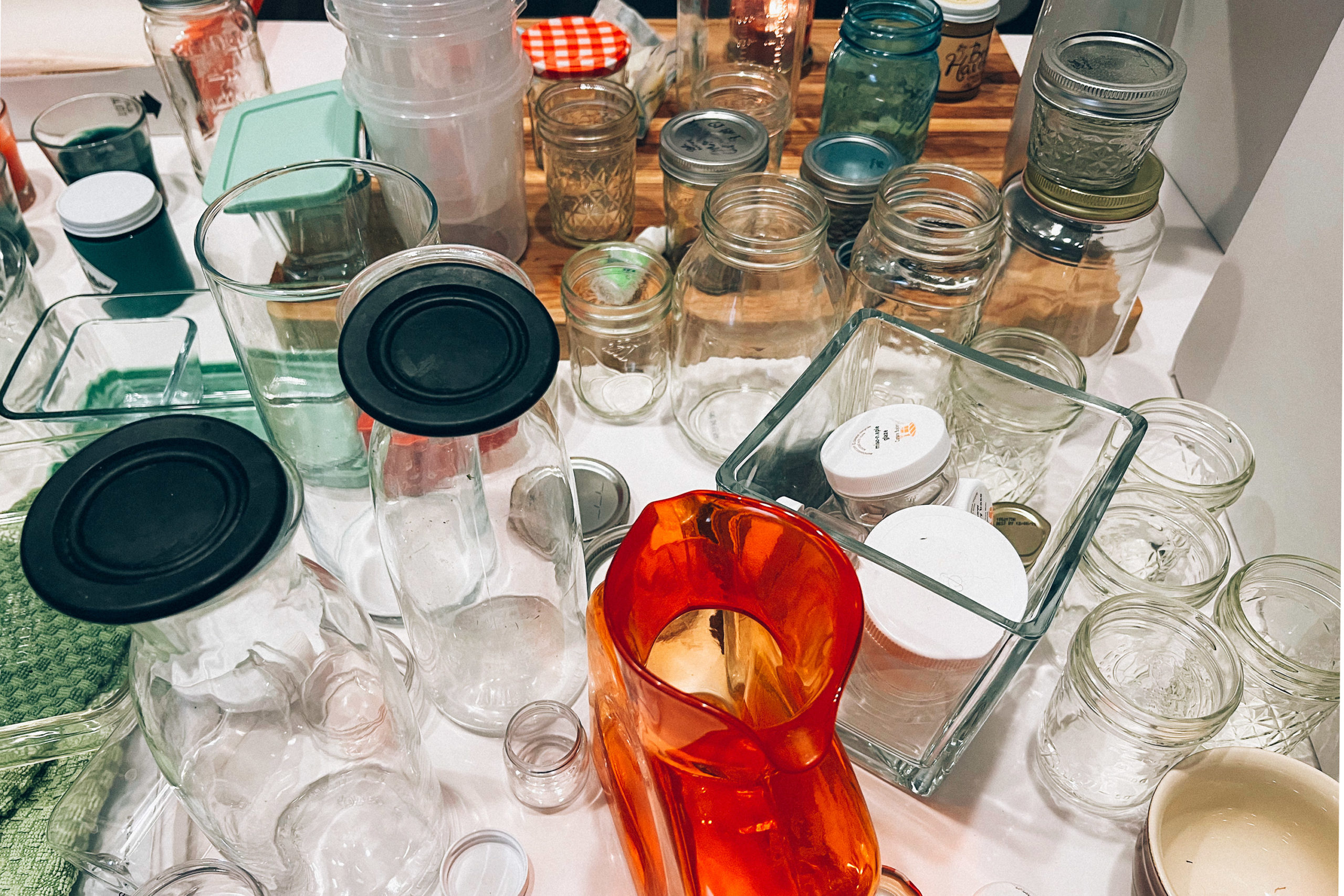 A counter-top filled with empty jars and other glass vessels