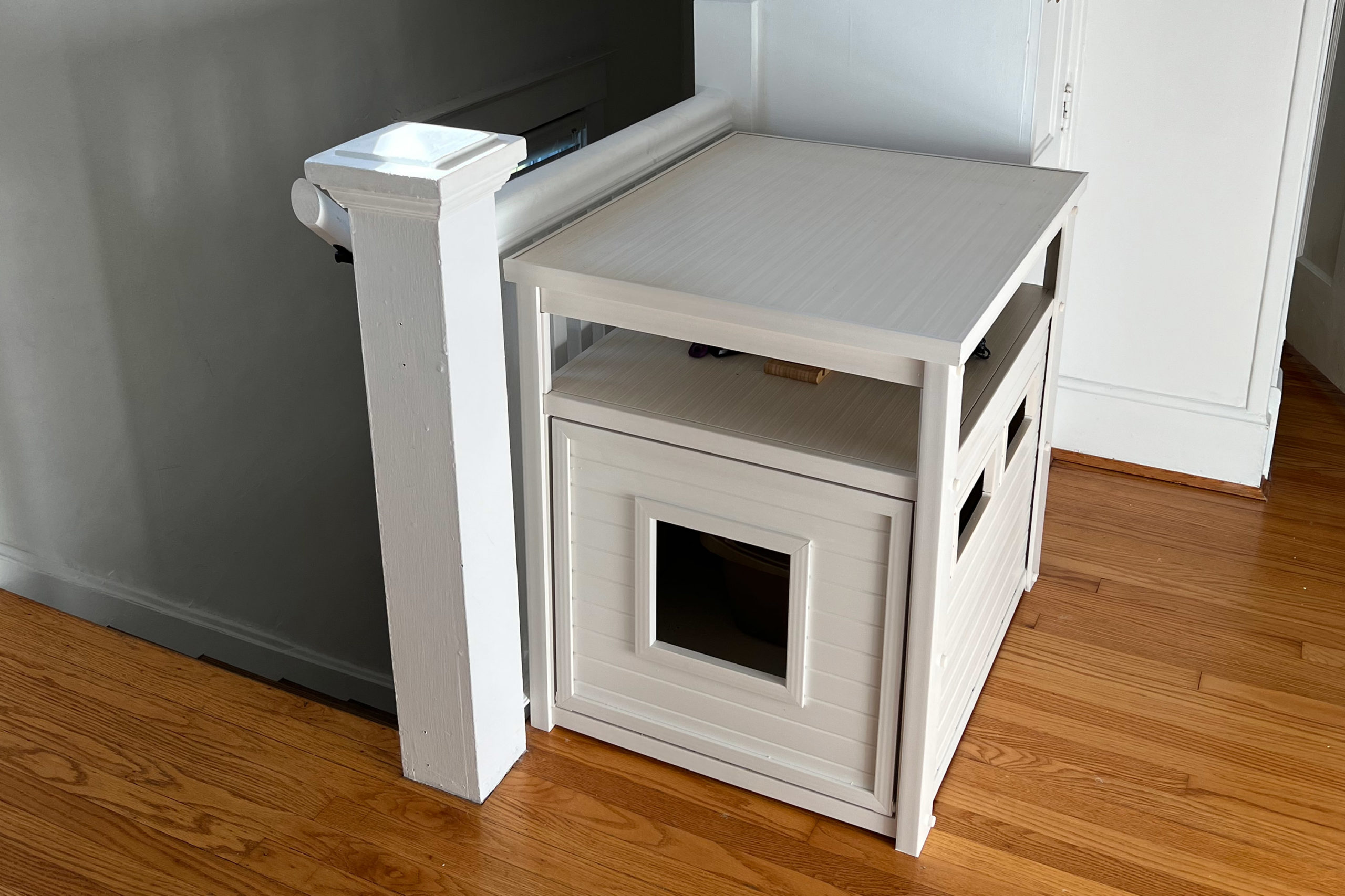 A fancy cat litter box piece of furniture