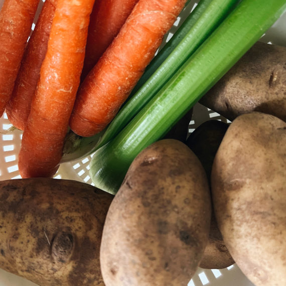 Carrots, celery and potatoes in a strainer