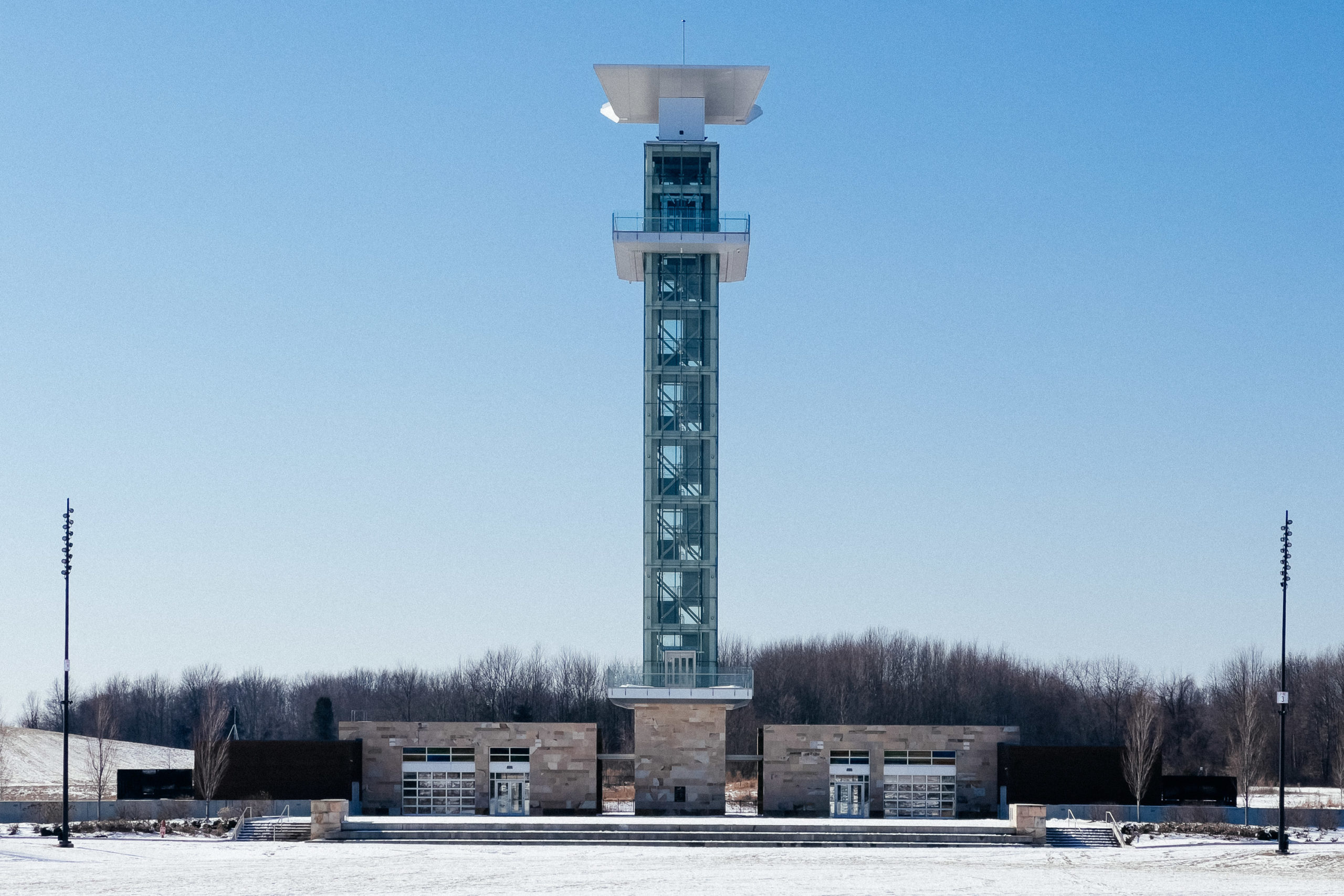 A tall lookout tower on a winter day with pale blue skies