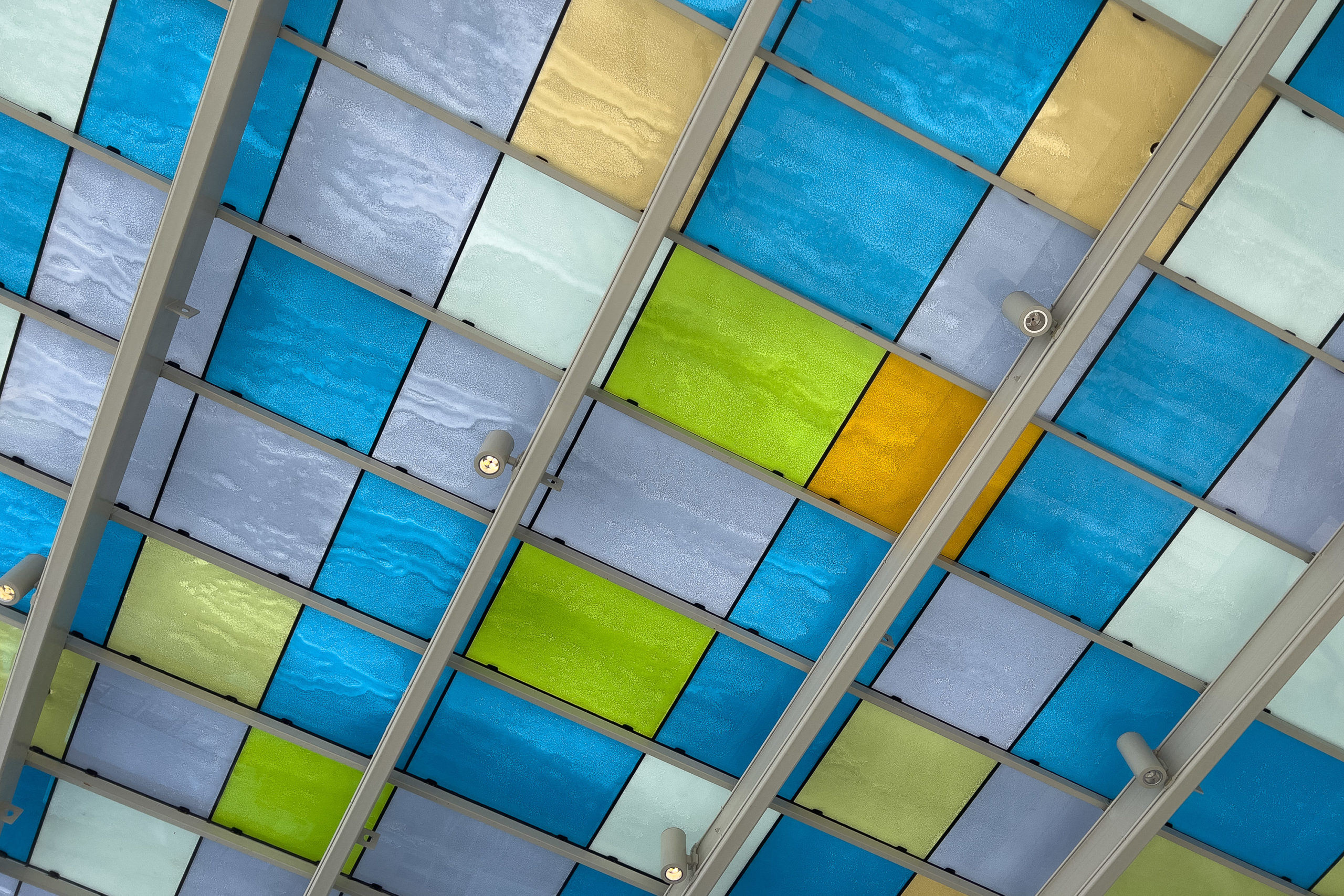 Blue, green, gray and a single orange square of glass of a roof