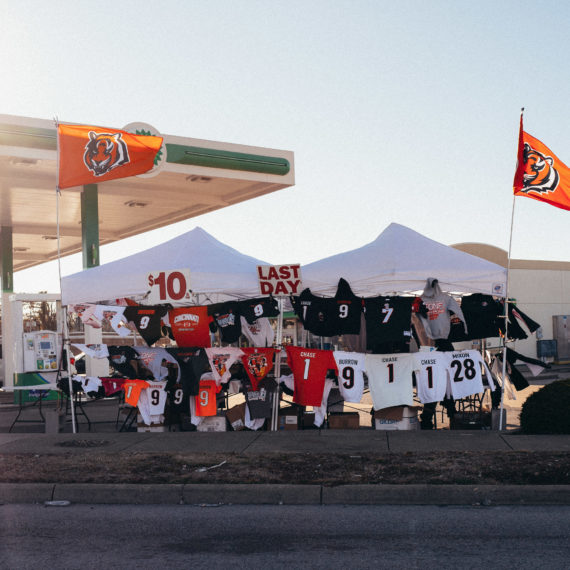 A tent with unofficial Bengals football themed t-shirts at the corner of a gas station