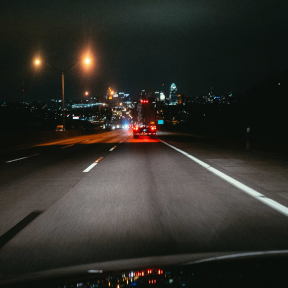 A blurry photo of a car driving on a highway into a city