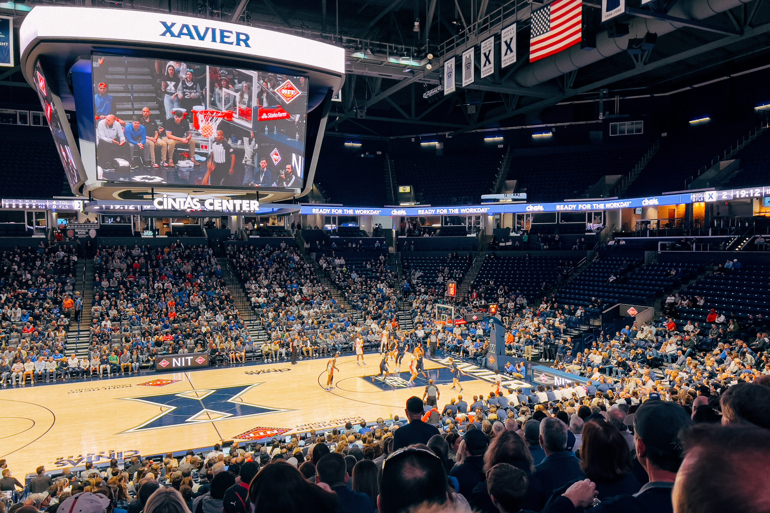 College basketball players in play on a court in an arena