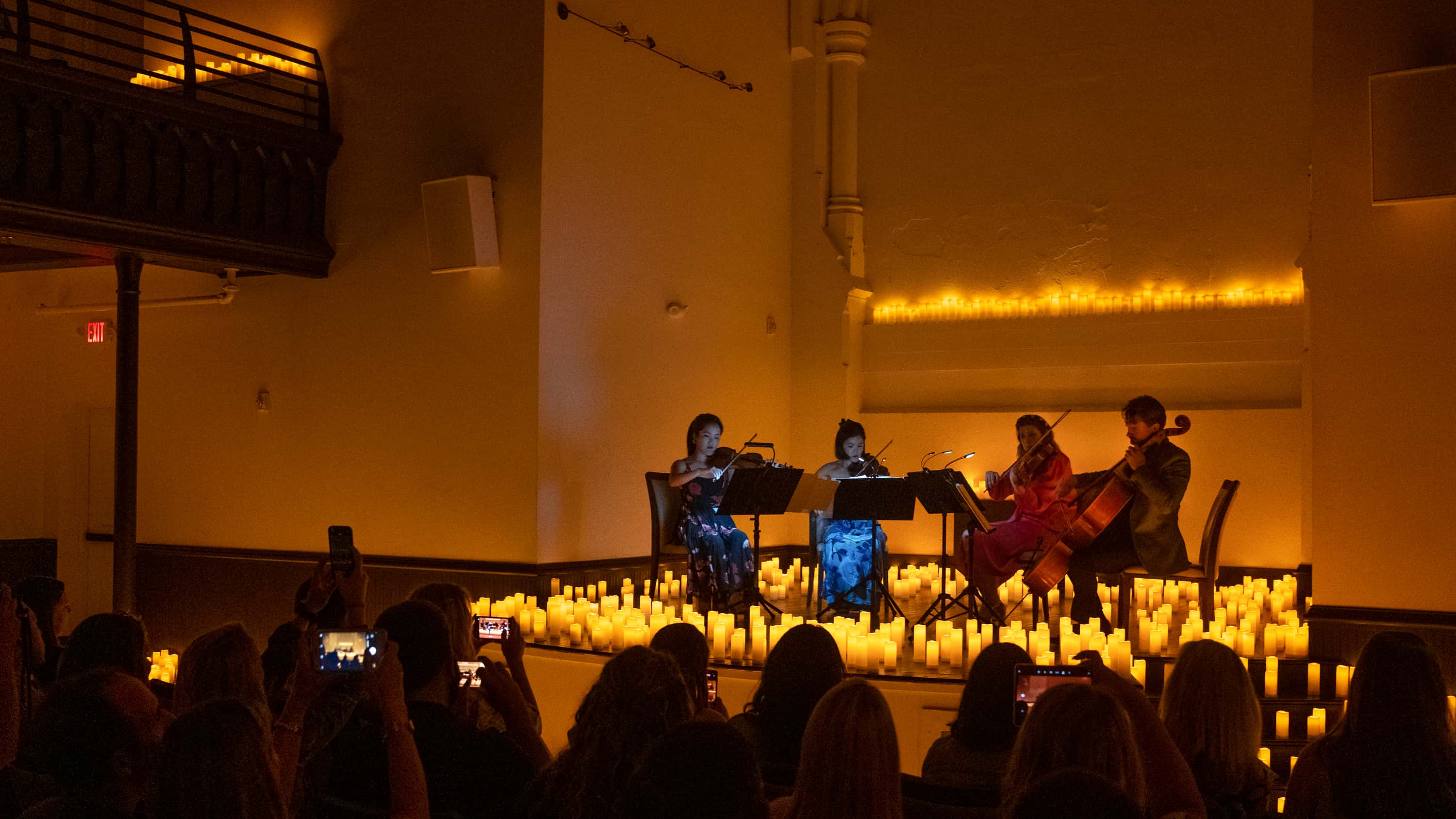 A string quartet performs in a church surrounded by hundreds of (LED) candles