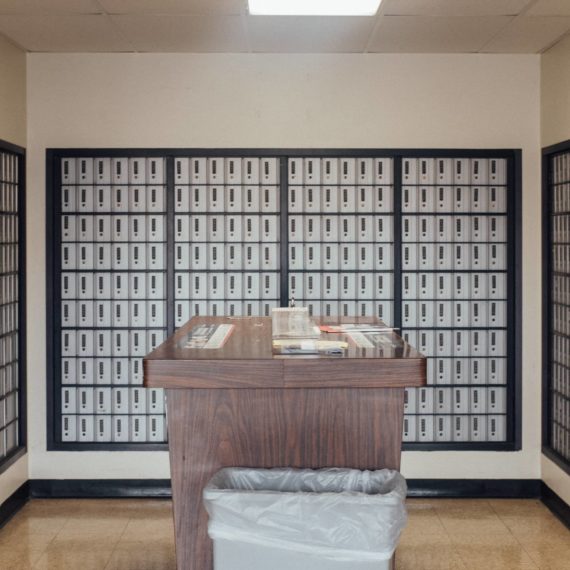 PO Boxes and a table with supplies in a post office lobby