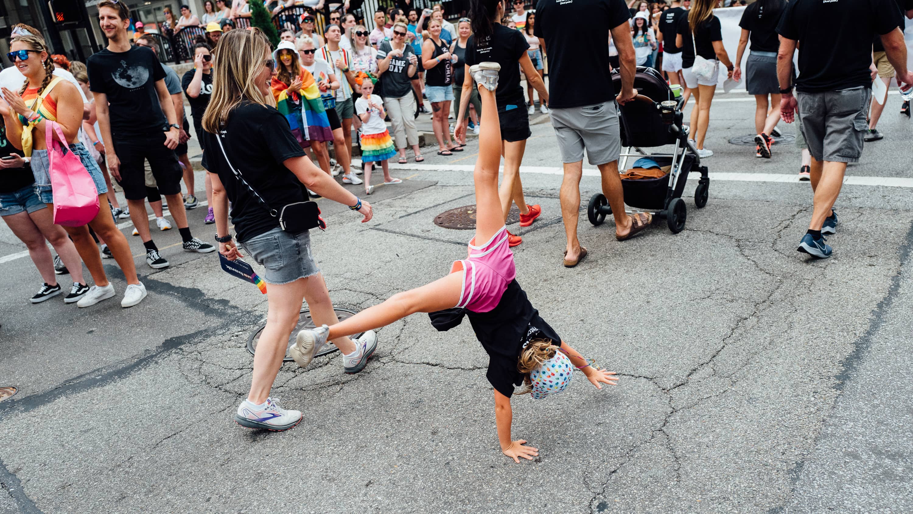 A girl does a cartwheel in a parade