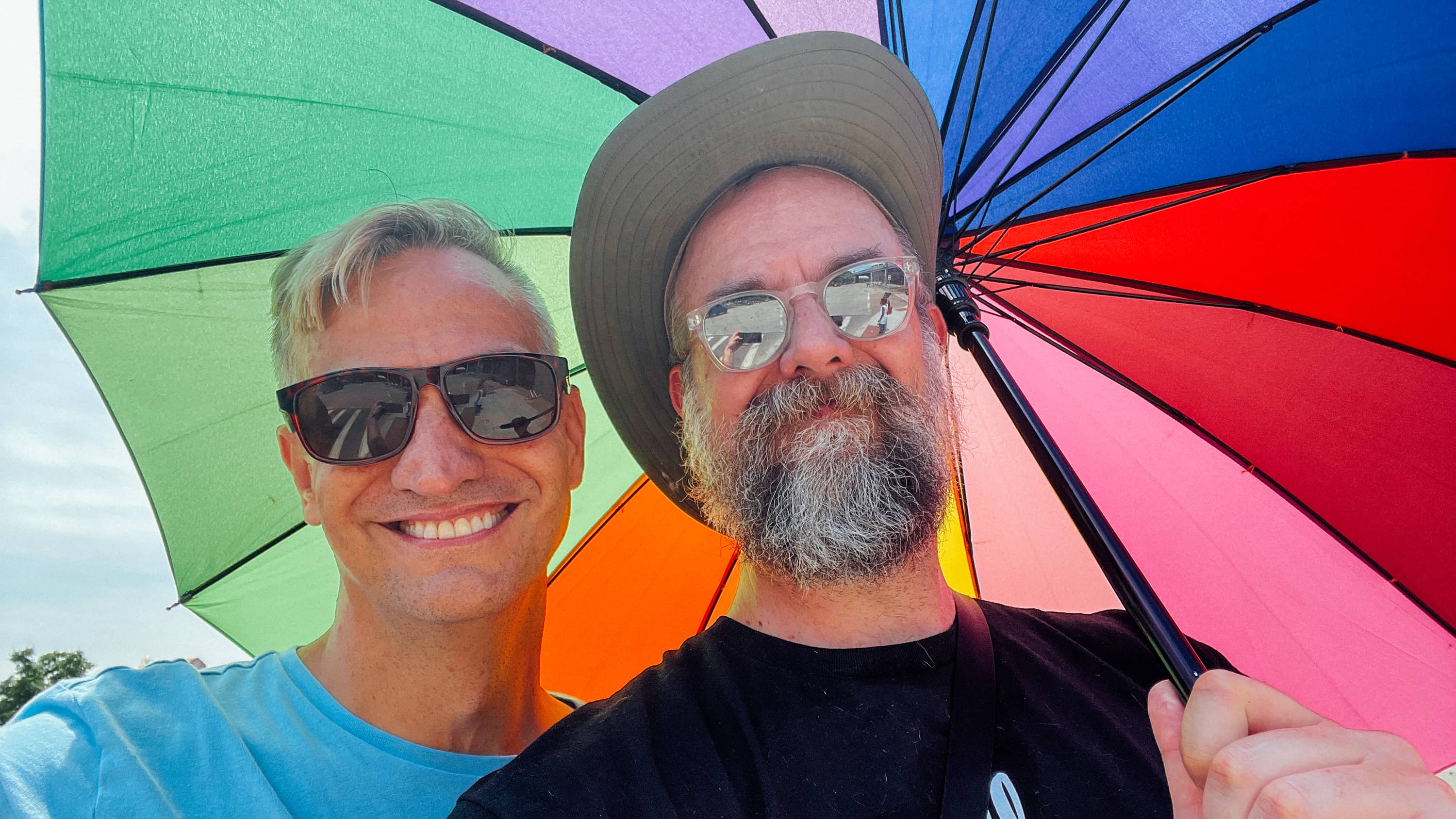 Two brothers take a selfie under a rainbow umbrella