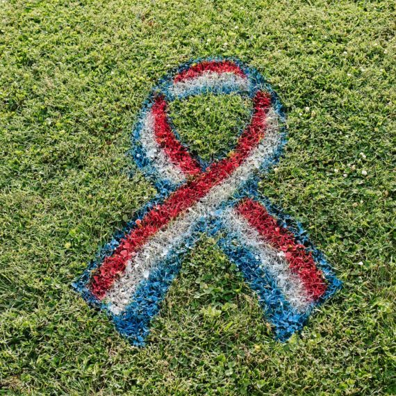 A red white and blue ribbon spray painted on a lawn