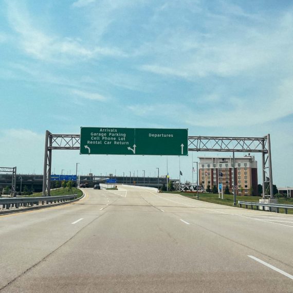 Driving up to an airport with signage for arrivals and departures