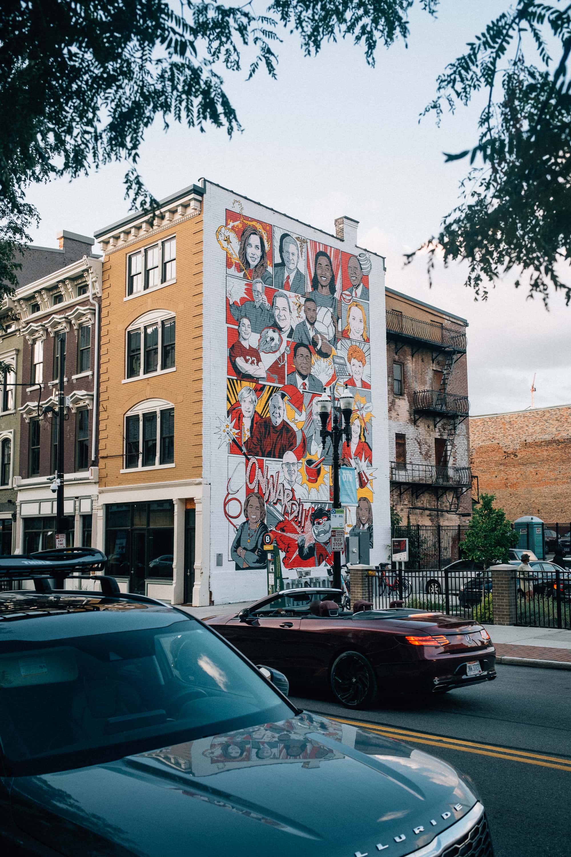 A mural of people on the side of a building in a city