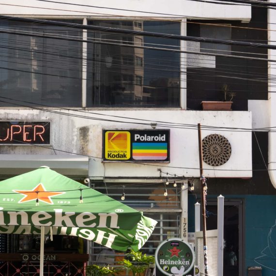 A neon sign that says SUPERDUPER and an old Kodak Polaroid sign in front of a business in San Juan Puerto Rico