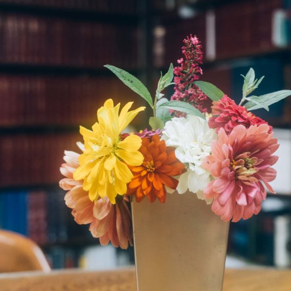 A metal vase of flowers in a library of a law office