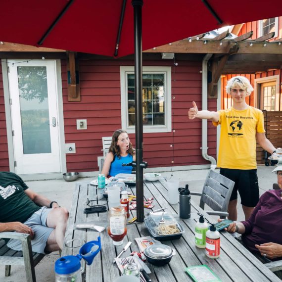 A family poses for the camera around an outdoor table after a meal of takeout