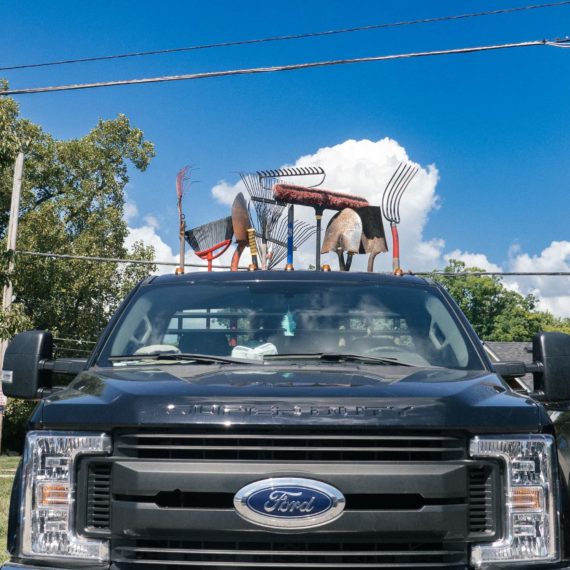 A large Ford pickup truck with a row of garnering utensils aligned behind the cab