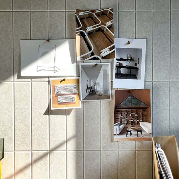 Beige vertical wall tiles made of felt with items pinned to them