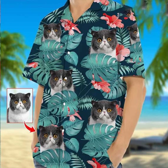 A Hawaiian shirt with cat faces tucked behind palm leaves