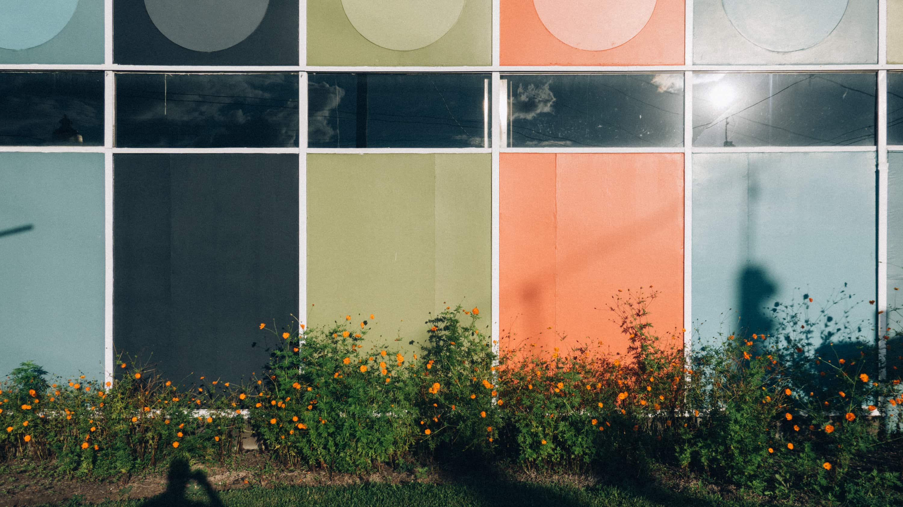 A mid-century modern auto mechanic building with panels of pastel colors for the exterior