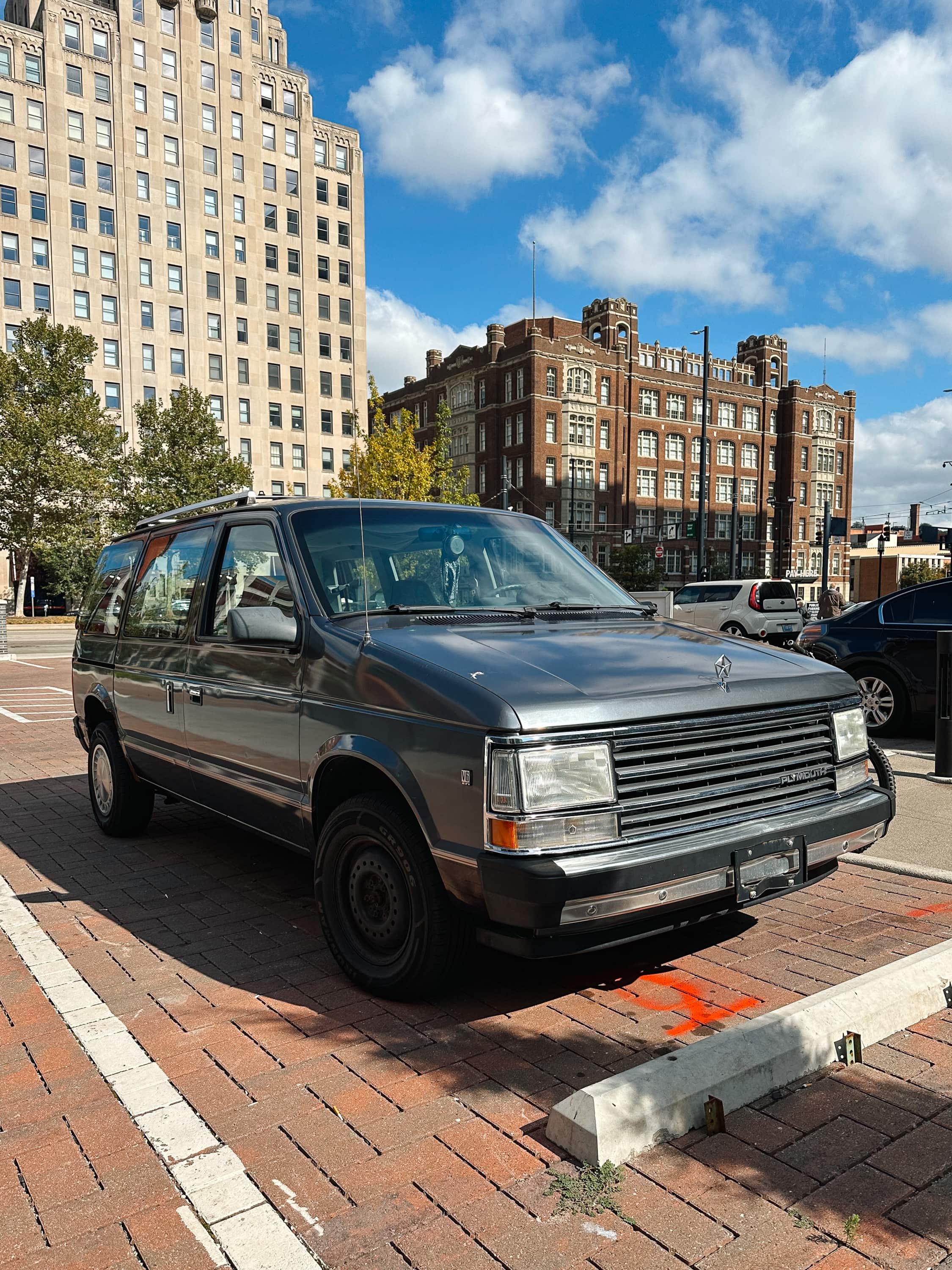 A Plymouth Voyager with art deco buildings in the background