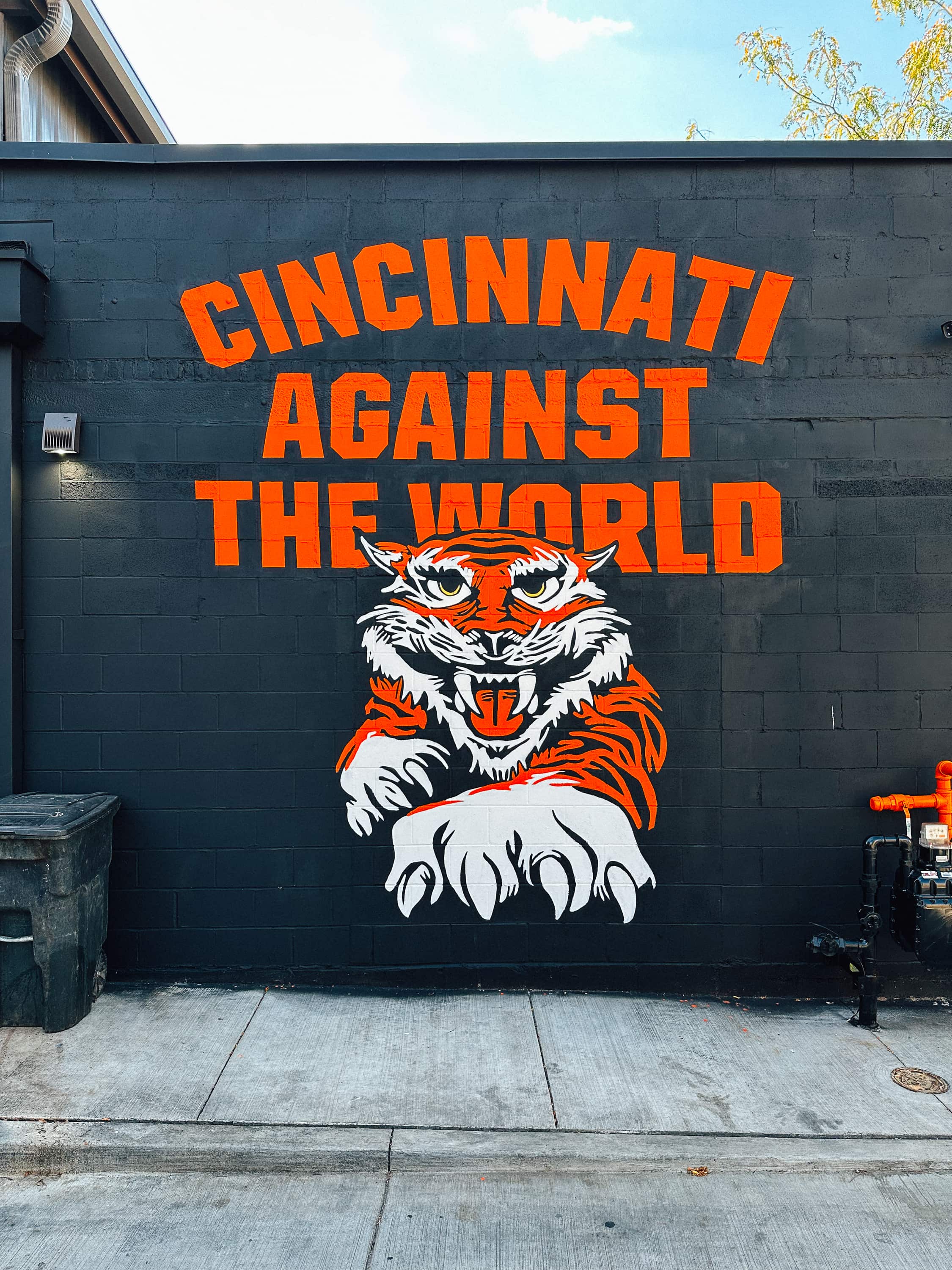 Mural of tiger jumping outward with bright orange text that reads "CINCINNATI AGAINST THE WORLD"