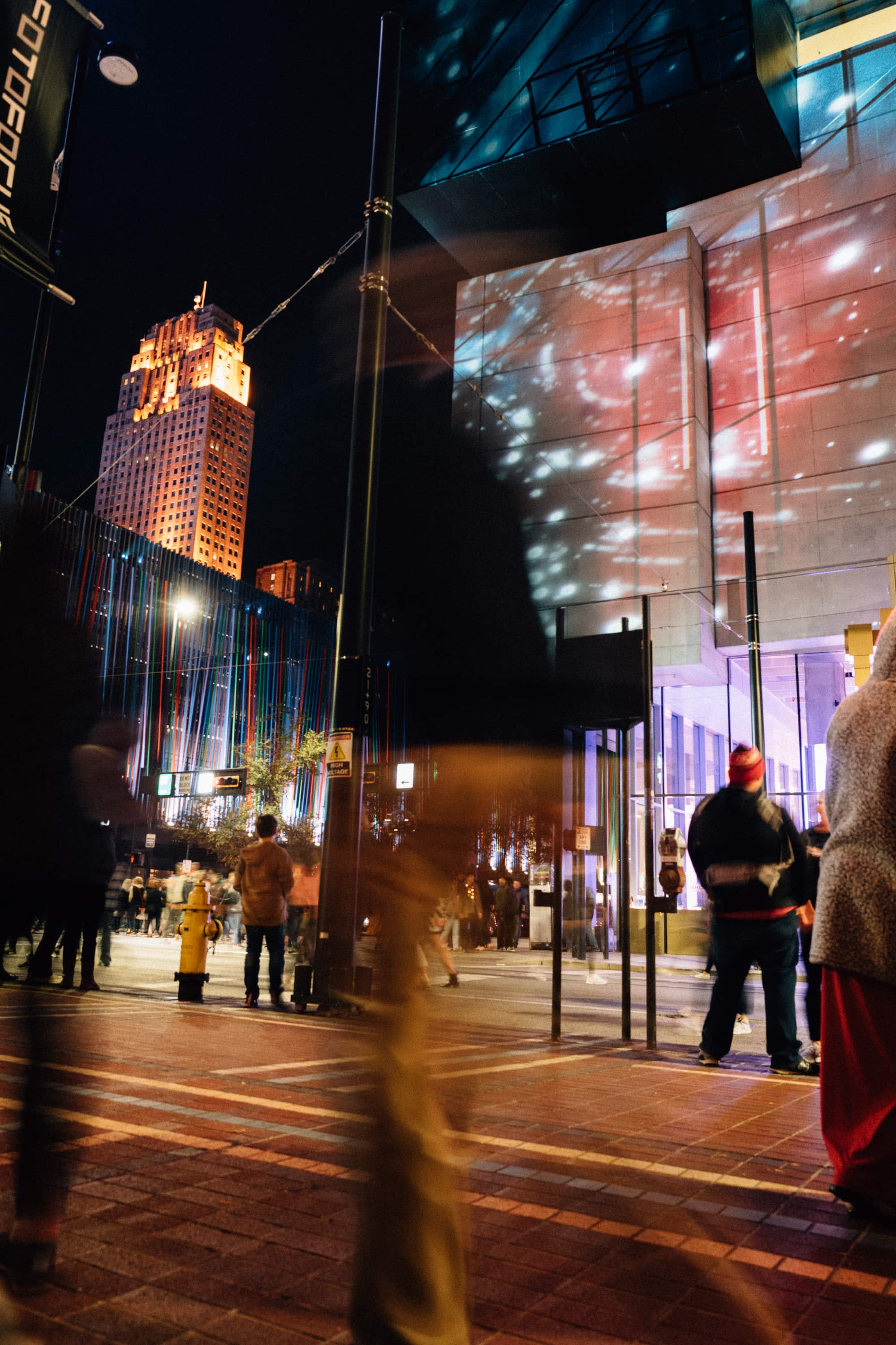 Blurry figure walks by a light installation