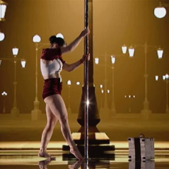 A woman on stage at the beginning of a pole dance