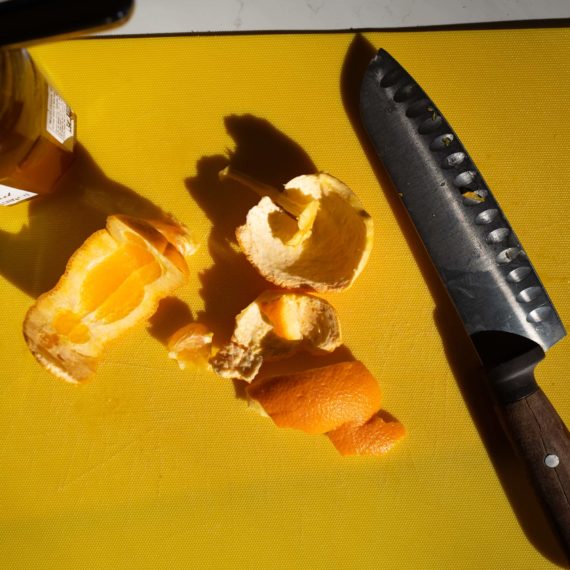 Slicing up an orange on a yellow plastic cutting board