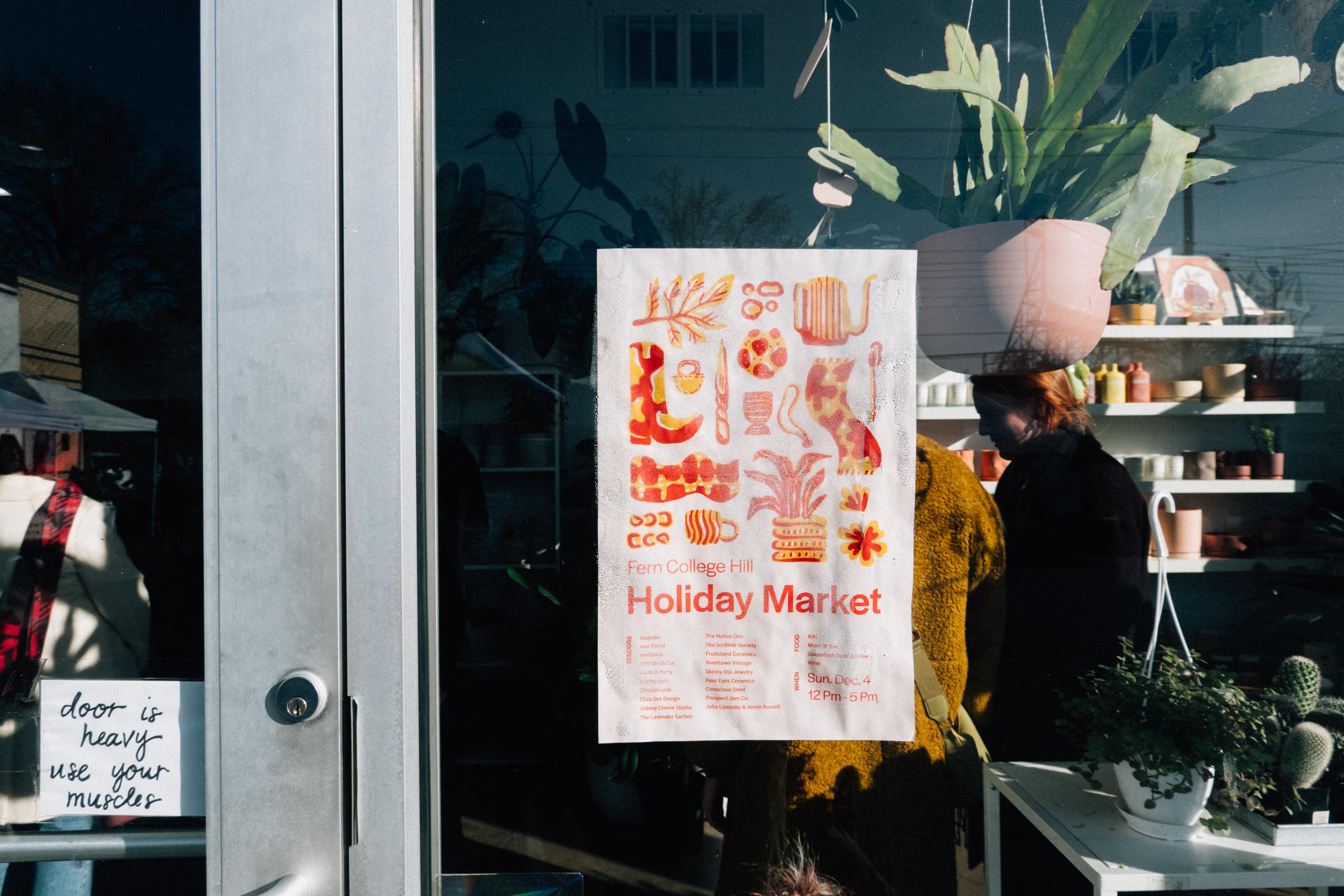 Fern Holiday Market poster in the window of a plant and homeware store