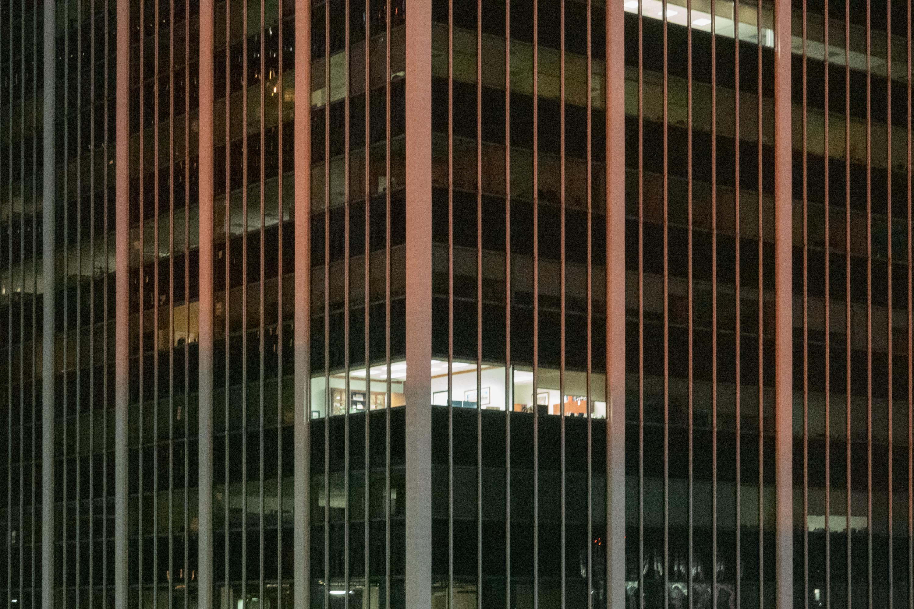 Office building with a light left on in a corner office