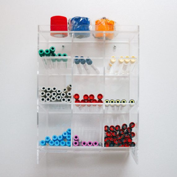 A shelf with empty vials with different colored lids used for blood samples