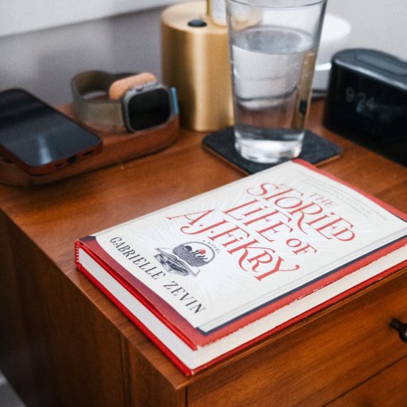 A hardback book titled "The Storied Life of A.J. Fikry" on a nightstand