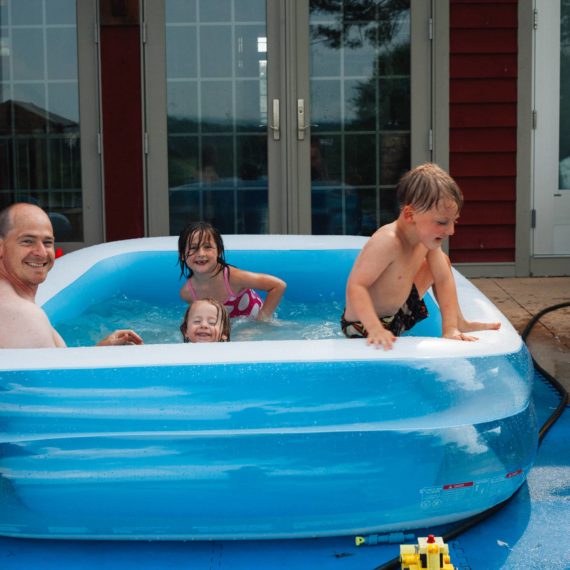 Father with kids in inflatable pool