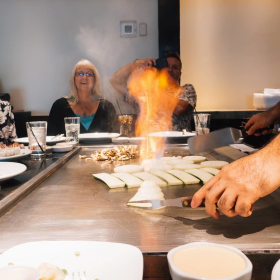 A chef at Benihana lights an onion on the teppan grill