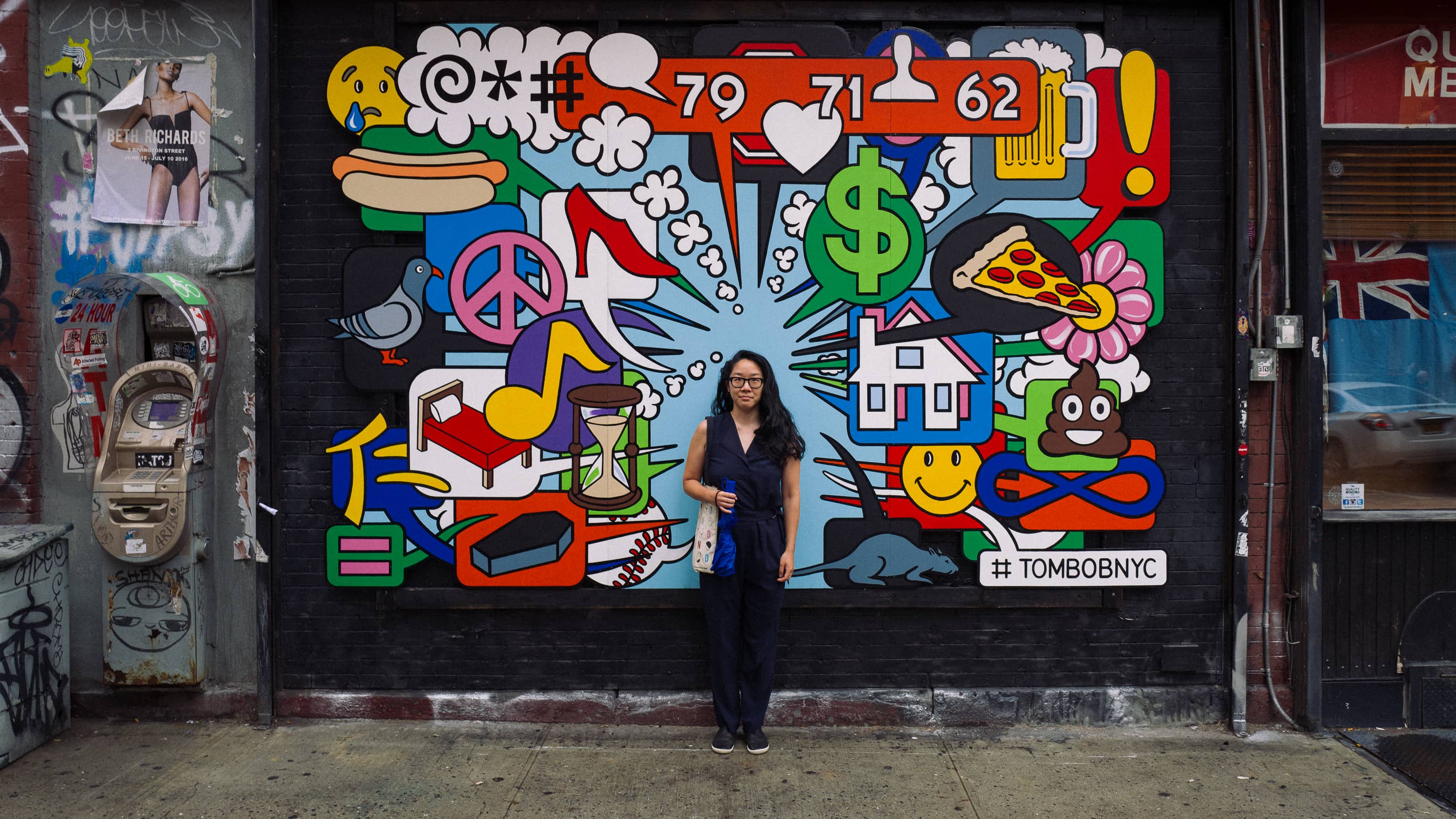 A person stands in front of a mural