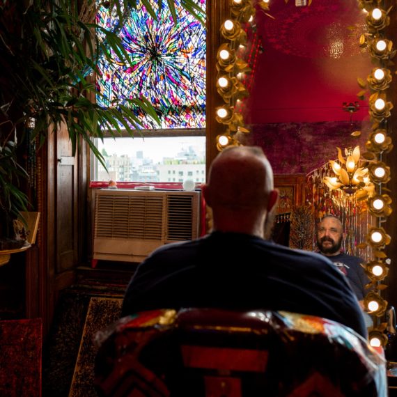 A man looks in the mirror after a haircut in New York City