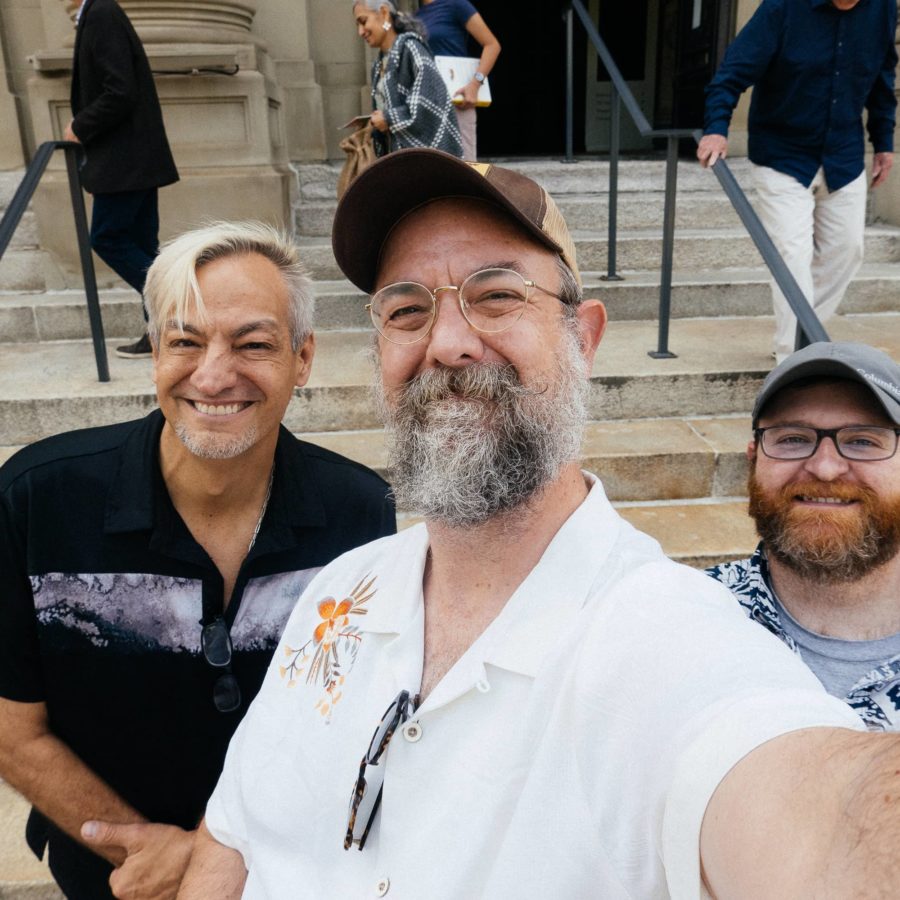 Three men take selfie outside of Memorial Hall in CIncinnati