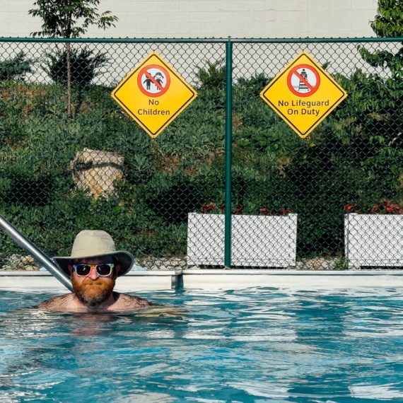 Man with wide brimmed hat and sunglasses in pool