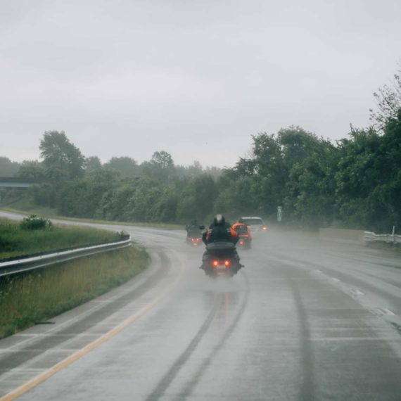 Motorcycles on a rainy highway. The spray from the rear wheel makes it look like the bike is hovering.