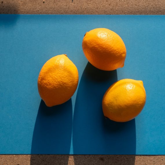 Three lemons on a blue sheet of paper