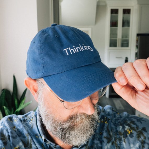 A blue cap that says Thinking across the brim